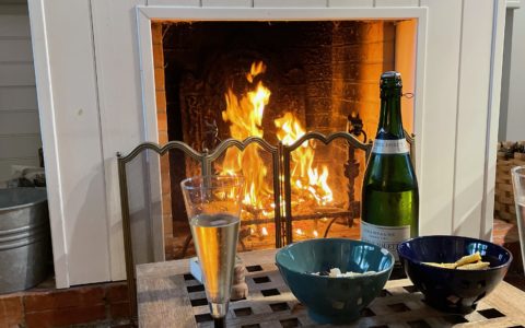 Une bouteille de champagne devant un feu de cheminée